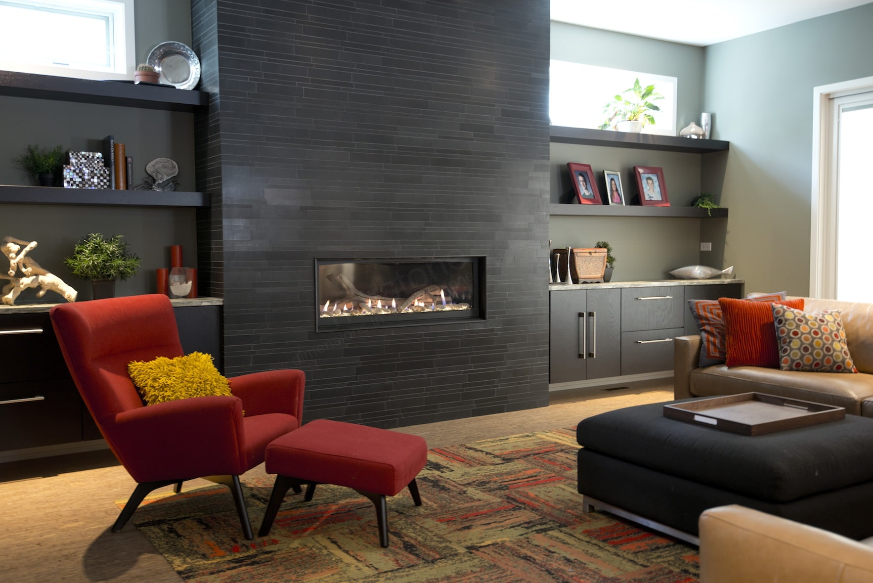 Norstone Natural Stone Veneer Ebony Lynia Interlocking Tile used on a modern fireplace with a contrasting colored red chair